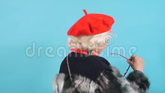 笑着穿着红帽子和黑外套的快乐奶奶视频的预览图