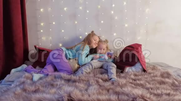 两个女孩姐妹在床上用双手玩捉迷藏视频的预览图