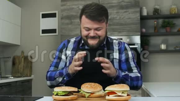 满意丰满的男人对他做的汉堡包很高兴脸上露出笑容不健康的生活方式油炸和高热量视频的预览图