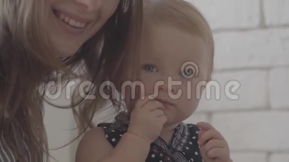 无法辨认的微笑年轻女子带着她的孩子看着相机幸福家庭一个孩子爱的概念视频的预览图