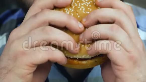 特写胡子的人咬了一个他做的汉堡包他吃自制的食物不健康的生活方式油炸和高热量视频的预览图