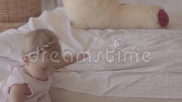 小女孩在室内的床上玩耍在家可爱的孩子和妈妈在一起的漂亮孩子玩得开心慢动作视频的预览图