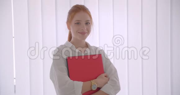 年轻漂亮的白种人红发女商人手持笔记本电脑开心地看着相机微笑的特写镜头视频的预览图