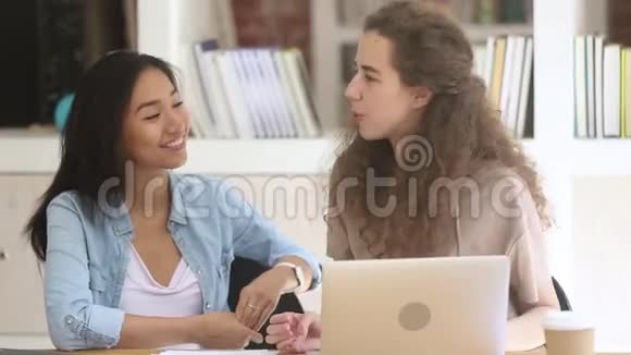 两个不同的女生在校园里一起学习视频的预览图