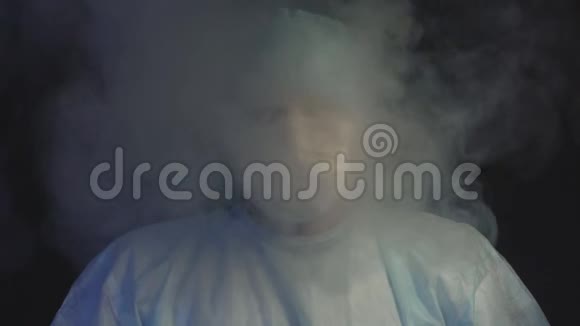 外科医生站在烟雾的黑色背景下对吸烟和燃烧的烟雾慢动作的疾病的概念视频的预览图