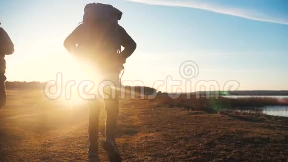 两名游客一起背着背包慢动作行走在阳光下剪影在生活方式的夕阳下视频的预览图