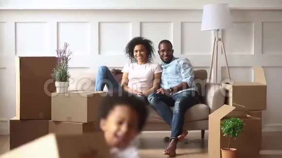 兴奋的非洲小孩拿着盒子在客厅里玩视频的预览图