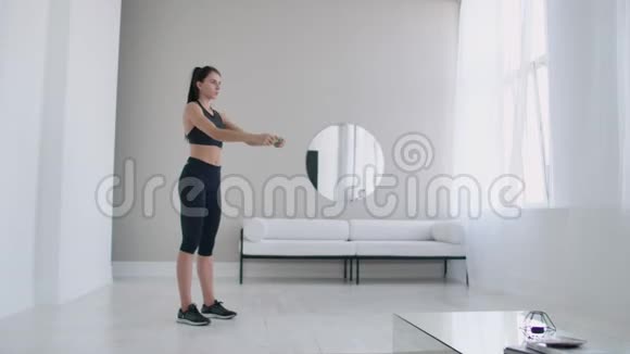 布鲁内特女士早上在她的公寓里做热身和运动用手臂盲目地向右转动身体视频的预览图