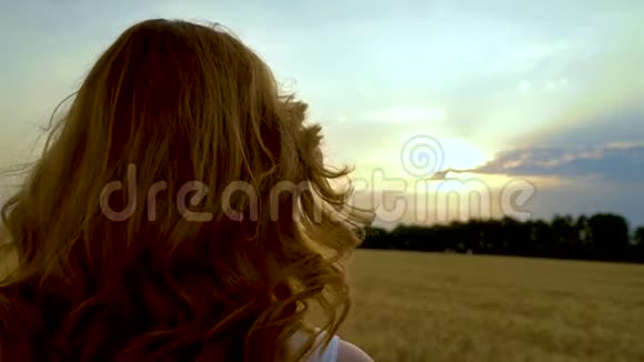 日落时分观看阳光冲破云层的女人的后景视频的预览图