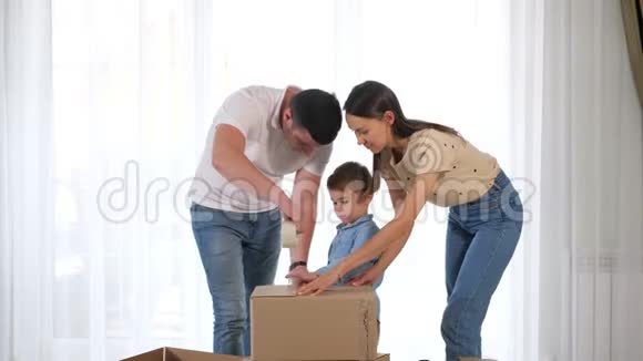 小两口帮小儿子装大盒子用胶带粘视频的预览图