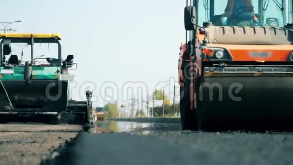 正在施工的阿斯普拉特公路一台机器在铺设沥青时骑在路上视频的预览图
