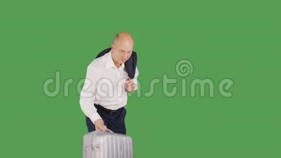 在绿色背景下商人扛起旅行箱持手提箱和夹克的游客视频的预览图