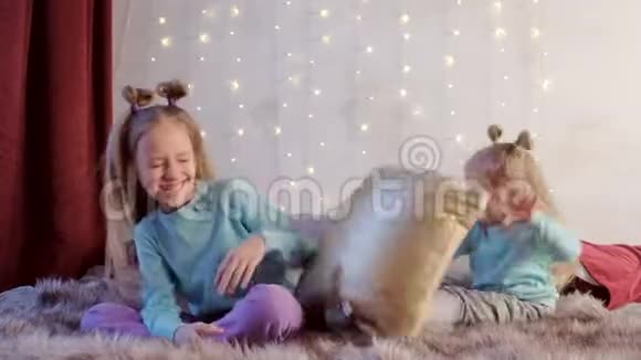 在圣诞节假期两个女孩姐妹一起在床上玩枕头视频的预览图