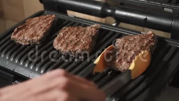 男人从烤架上拿起成品多汁的牛肉肉做牛排视频的预览图