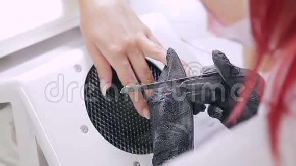 美容店里戴着手套的美甲师女士在涂胶前用指甲锉钉客户视频的预览图