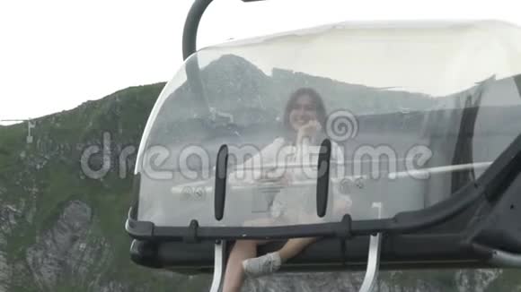微笑着美丽的年轻女子在山上乘坐索道视频的预览图