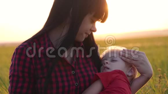 年轻漂亮的妈妈和婴儿一起在公园里散步小女儿睡在一位有爱心的母亲的怀里视频的预览图