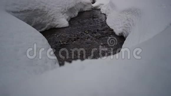雪鞋在大雪滩的小溪旁视频的预览图