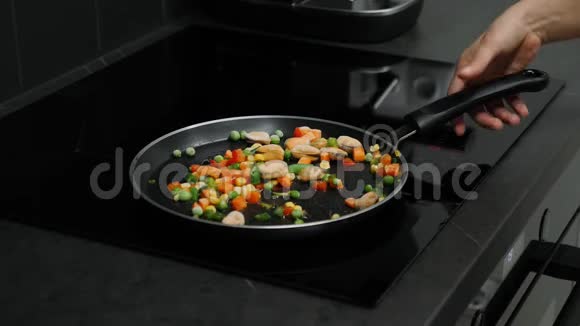 女人在感应板上的平底锅上煮煮蔬菜和贻贝女性准备和油炸蔬菜智能现代装备包视频的预览图
