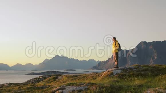 女游客从山上放松和欣赏挪威风景视频的预览图