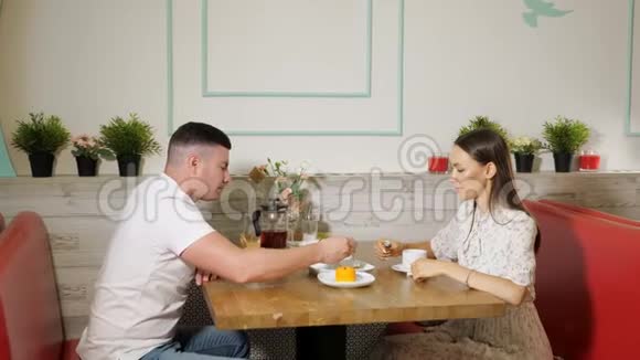 男人用美味的甜点喂女孩花时间在咖啡馆里视频的预览图