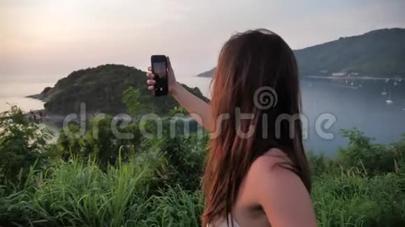 在美丽的景观背景上特写迷人的女人的肖像女性在山顶拍摄日落视频的预览图