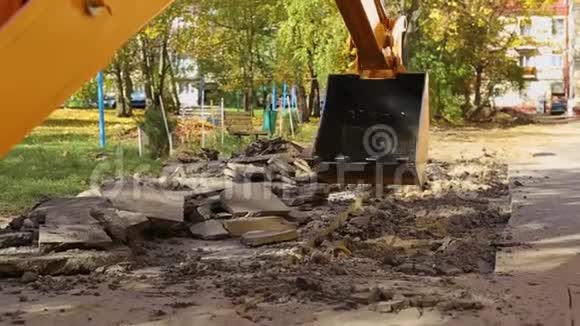 一挖掘机在一幢住宅楼的院子里挖后斗铺设煤气和供水取代旧的视频的预览图