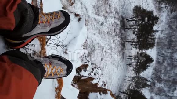 一个徒步旅行者腿坐在山顶的垂直POV视频视频的预览图