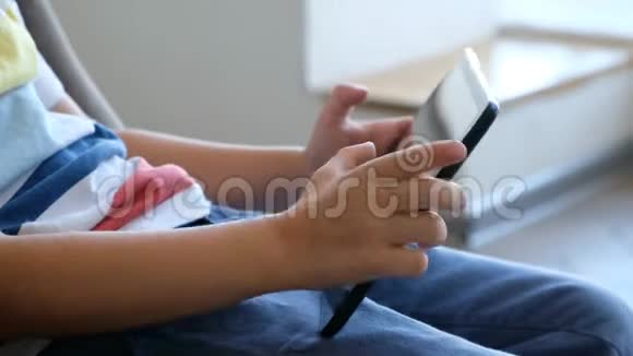 靠近孩子玩平板电脑的手视频的预览图