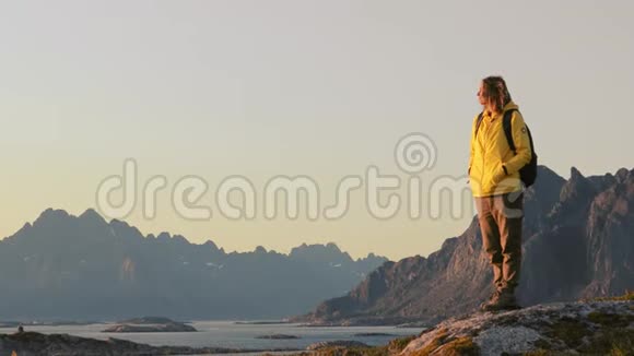 女游客从山上放松和欣赏挪威风景视频的预览图