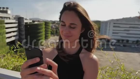 微笑女商人检查她的手机视频的预览图