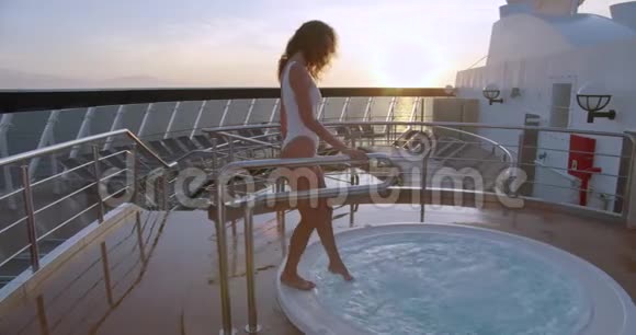 女人在热水浴缸按摩浴缸温泉与惊人的日出海景视频的预览图
