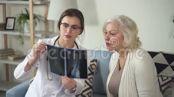 医生助理与高级妇女一起看X光视频的预览图