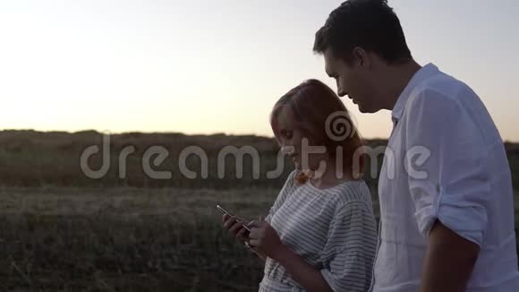 情侣们站在智能手机里观看视频的预览图