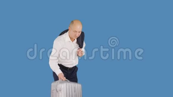 游客扛着蓝色背景的旅行箱穿着商务服的人肩上扛着手提箱视频的预览图