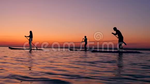 一群年轻的朋友正在日落时骑着桨板视频的预览图