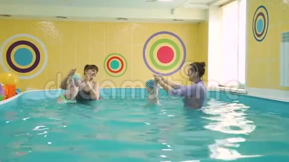 可爱的宝宝和游泳教练一起训练视频的预览图