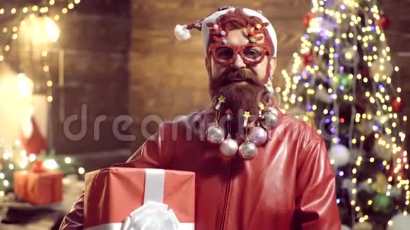 新年礼服胡子疯男人看着镜头很有魅力的留胡子的嬉皮士圣诞树圣诞老人视频的预览图