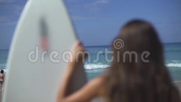 站在冲浪板上看水的女人视频的预览图