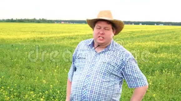 农夫站在田里说着什么在阳光明媚的日子戴牛仔帽视频的预览图