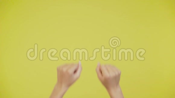 快乐的双手舞动着旋转孤立的黄色背景4K视频的预览图