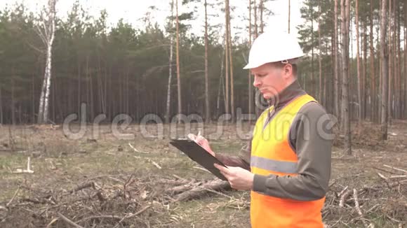 一位年轻的白种人男性检查员写下了森林和森林砍伐风景视频的预览图