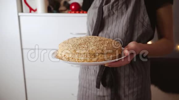 自制蜂蜜蛋糕在手里女人拿着甜美的食物在老式的乡村围裙的背景下视频的预览图