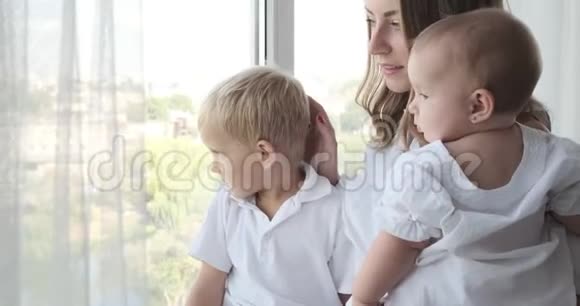 妈妈带着孩子从窗户往外看视频的预览图