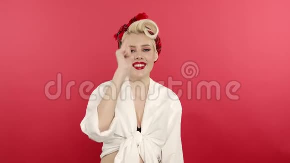 兴奋的金发女孩竖起大拇指在粉红色的背景上视频的预览图