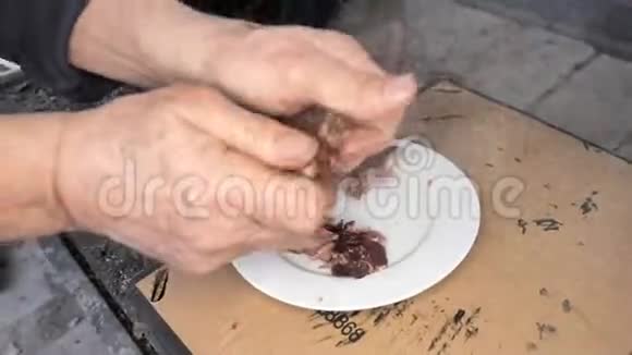 男性的手腕和手指从白盘上煮猪肉的骨头上折断肉晚餐准备期间品尝视频的预览图