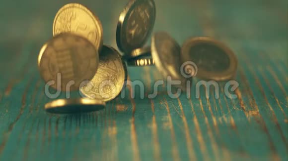 欧元硬币在蓝色木桌上掉落的超慢镜头视频的预览图