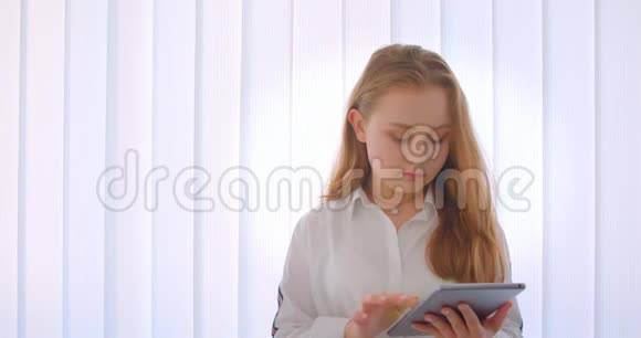 年轻可爱的白种人女孩的白种人女孩的特写肖像并在室内拍摄绿色彩色屏幕视频的预览图