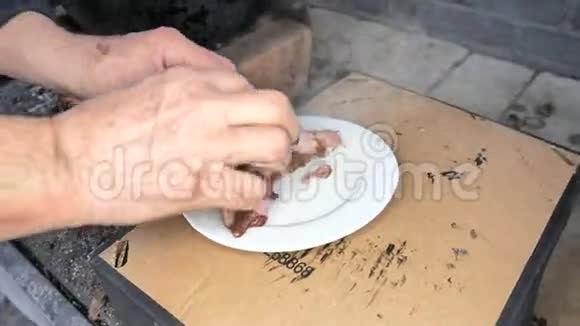老厨师用手指折断肋骨检查白盘上的熟肉准备食物时的禁食视频的预览图