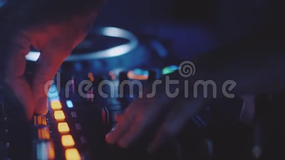 男子DJ在夜总会的混合控制台上演奏音乐视频的预览图